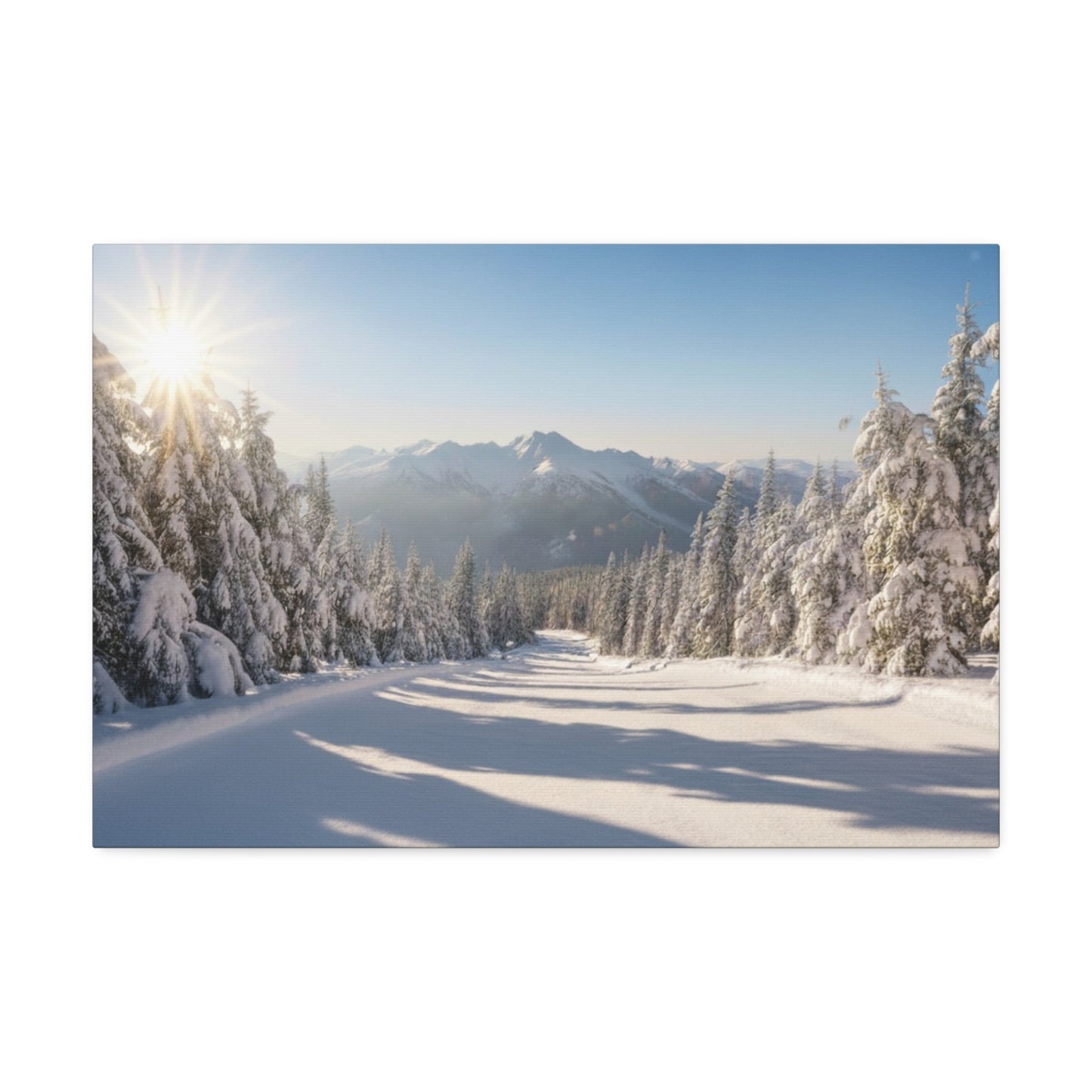 Canvas wall art depicting a serene snowy trail flanked by snow-covered pine trees under a clear sky with mountains in the background and sunlight casting long shadows.