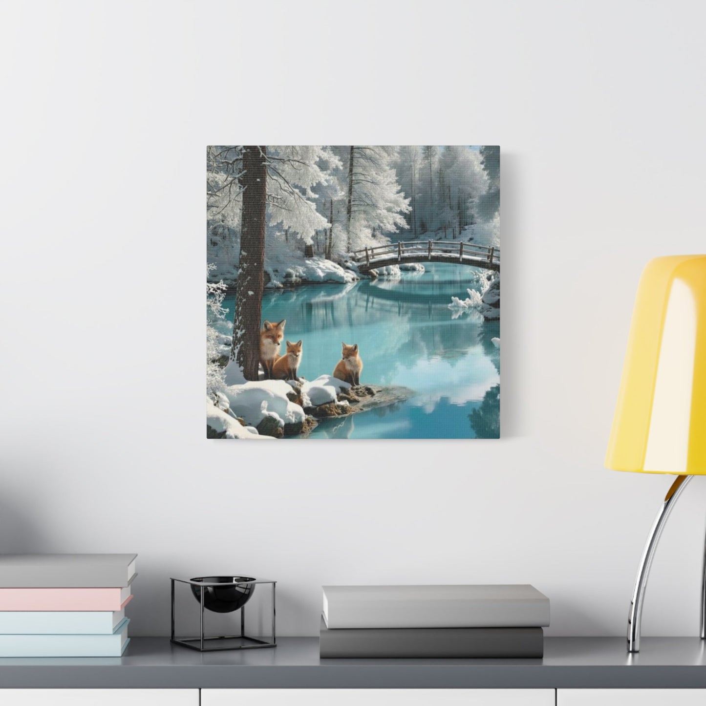 Canvas wall art featuring winter foxes by a snowy river with a wooden bridge in a serene landscape