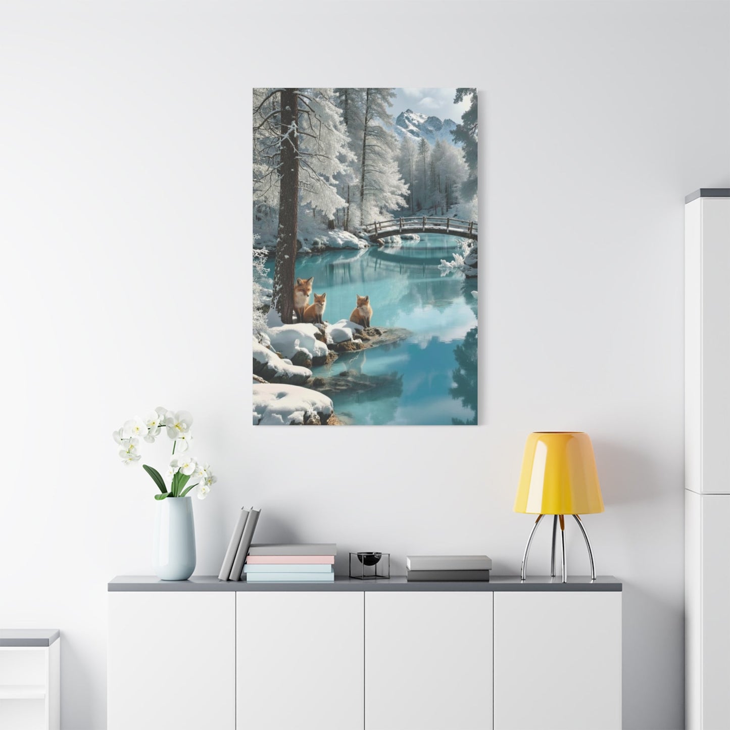 Canvas wall art depicting winter foxes by a snowy river with a bridge in a serene forest landscape.