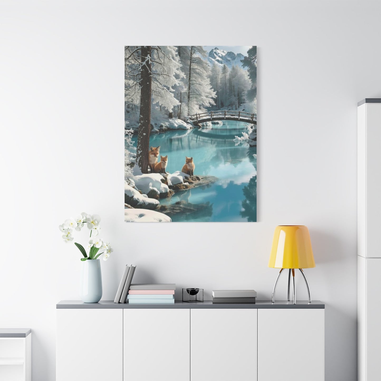 Canvas wall art featuring winter foxes by a snowy river with a wooden bridge in a serene landscape
