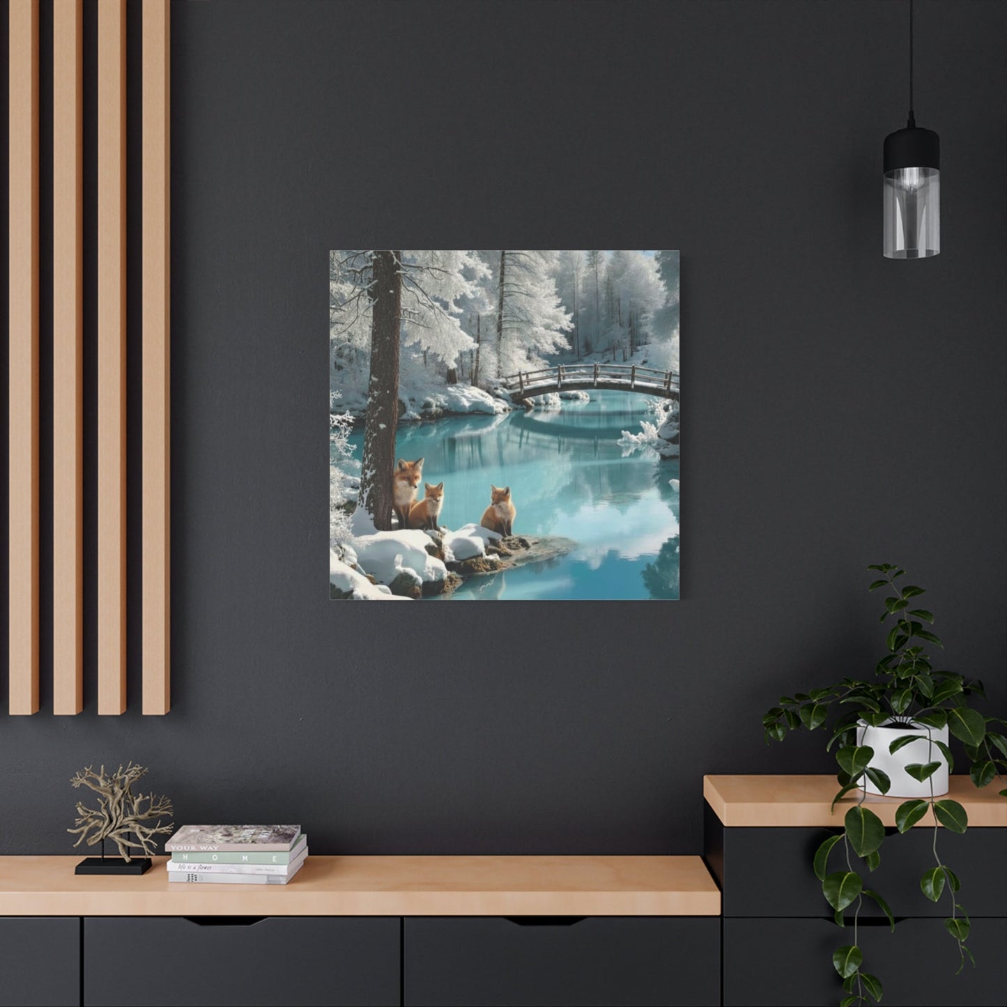 Canvas wall art depicting winter foxes by a snowy river with a wooden bridge in a modern living space