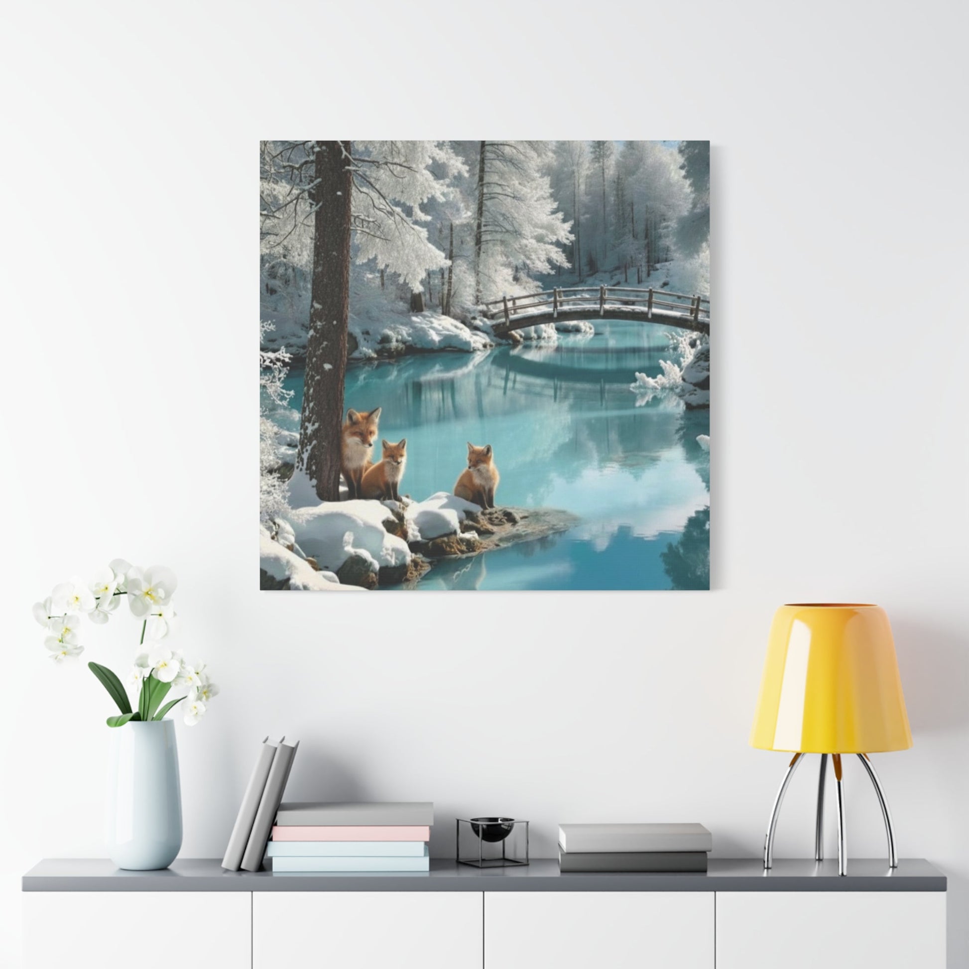 Canvas wall art featuring winter foxes by a snowy river with a wooden bridge and pine trees in a tranquil landscape