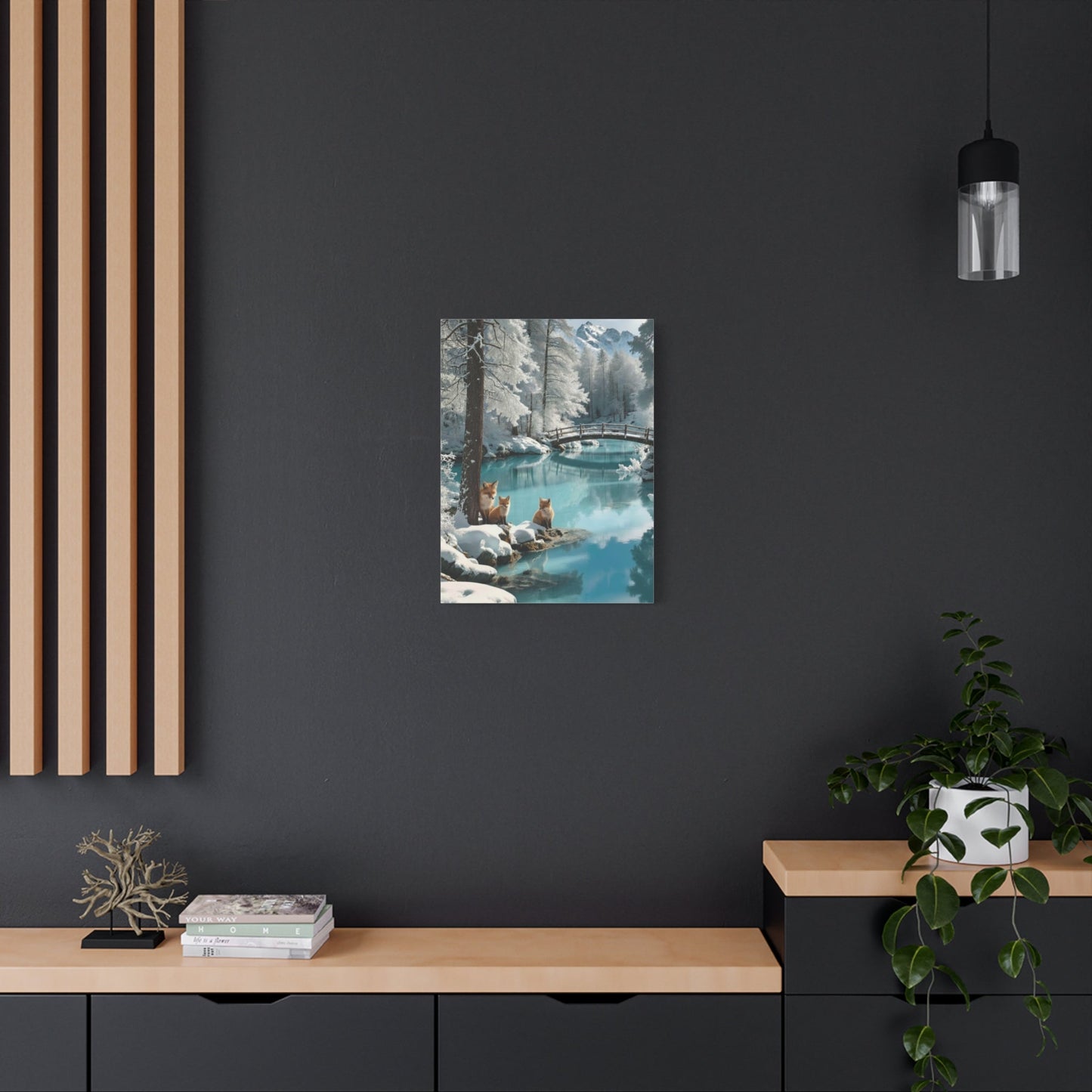 Canvas wall art featuring winter foxes by a snowy lakeside with a bridge, displayed in a modern living space.