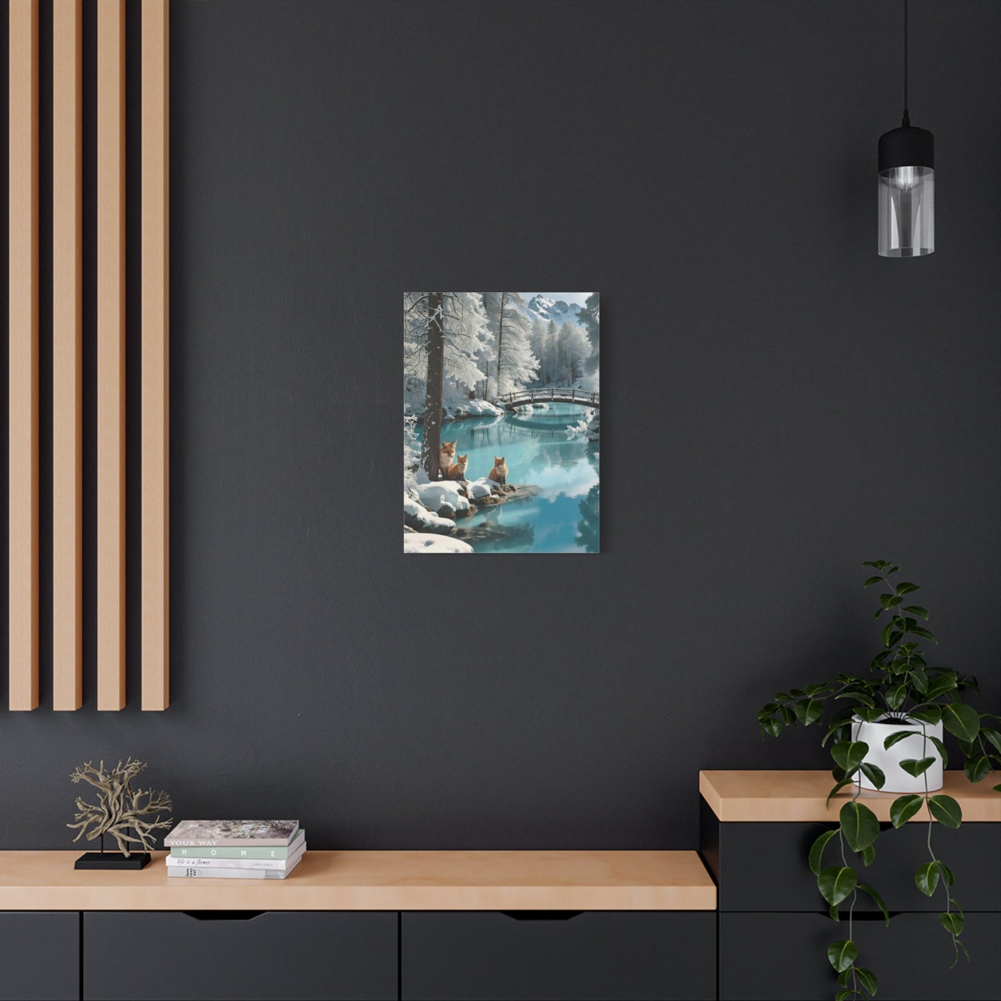 Canvas wall art featuring winter foxes by a snowy lakeside with a bridge, displayed in a modern living space.