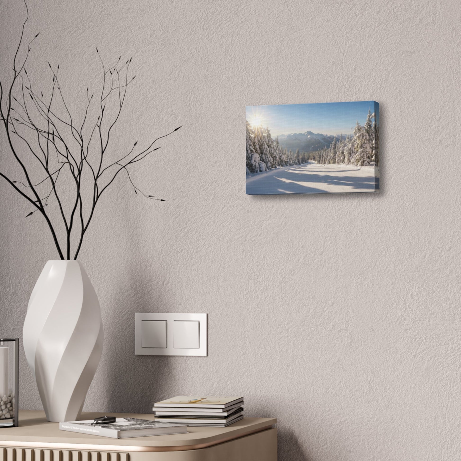 Canvas wall art displaying a serene snowy trail with pine trees and mountains under a clear sky in a modern room setting