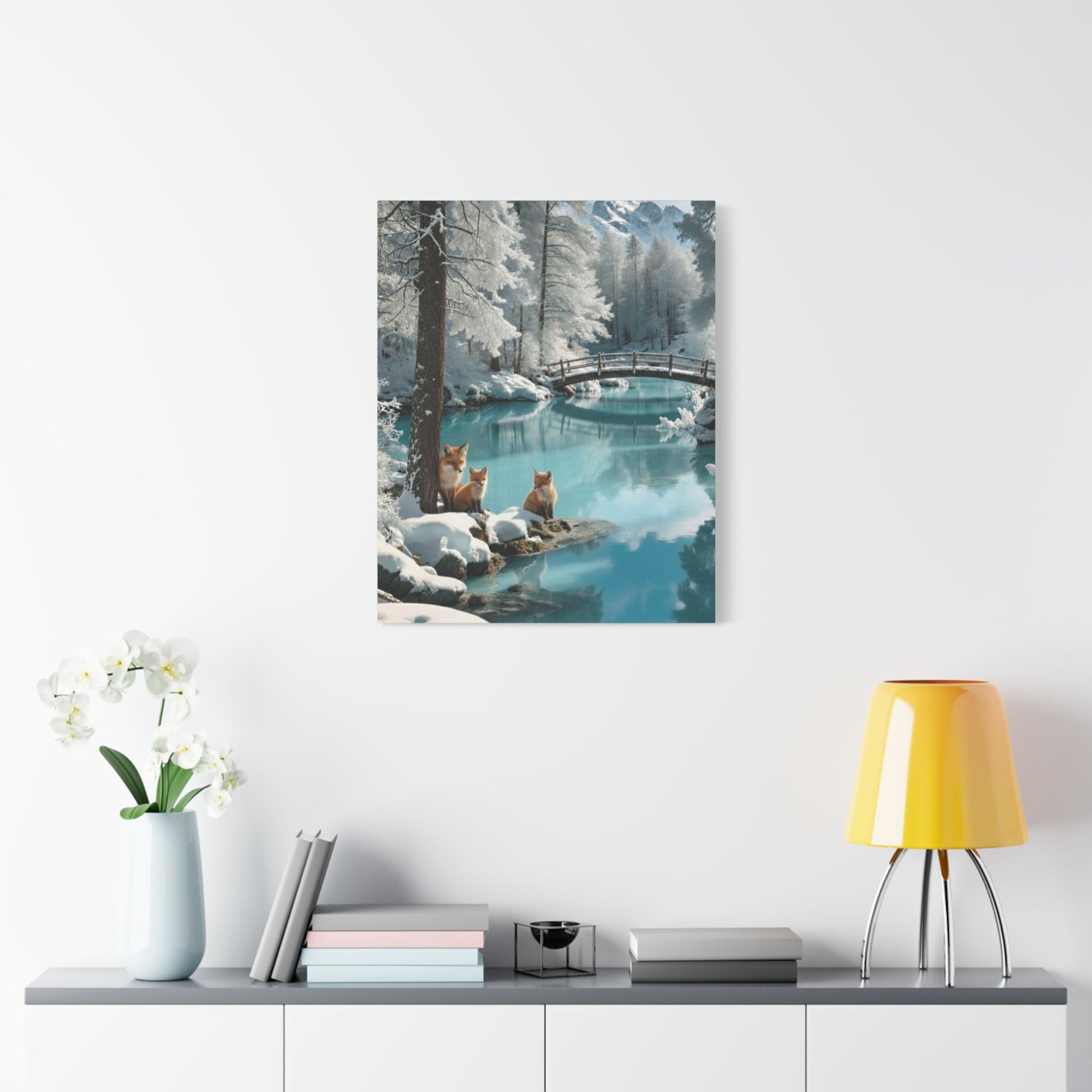 Canvas wall art depicting winter foxes by a snowy river with a wooden bridge in the background, perfect for cozy home décor.