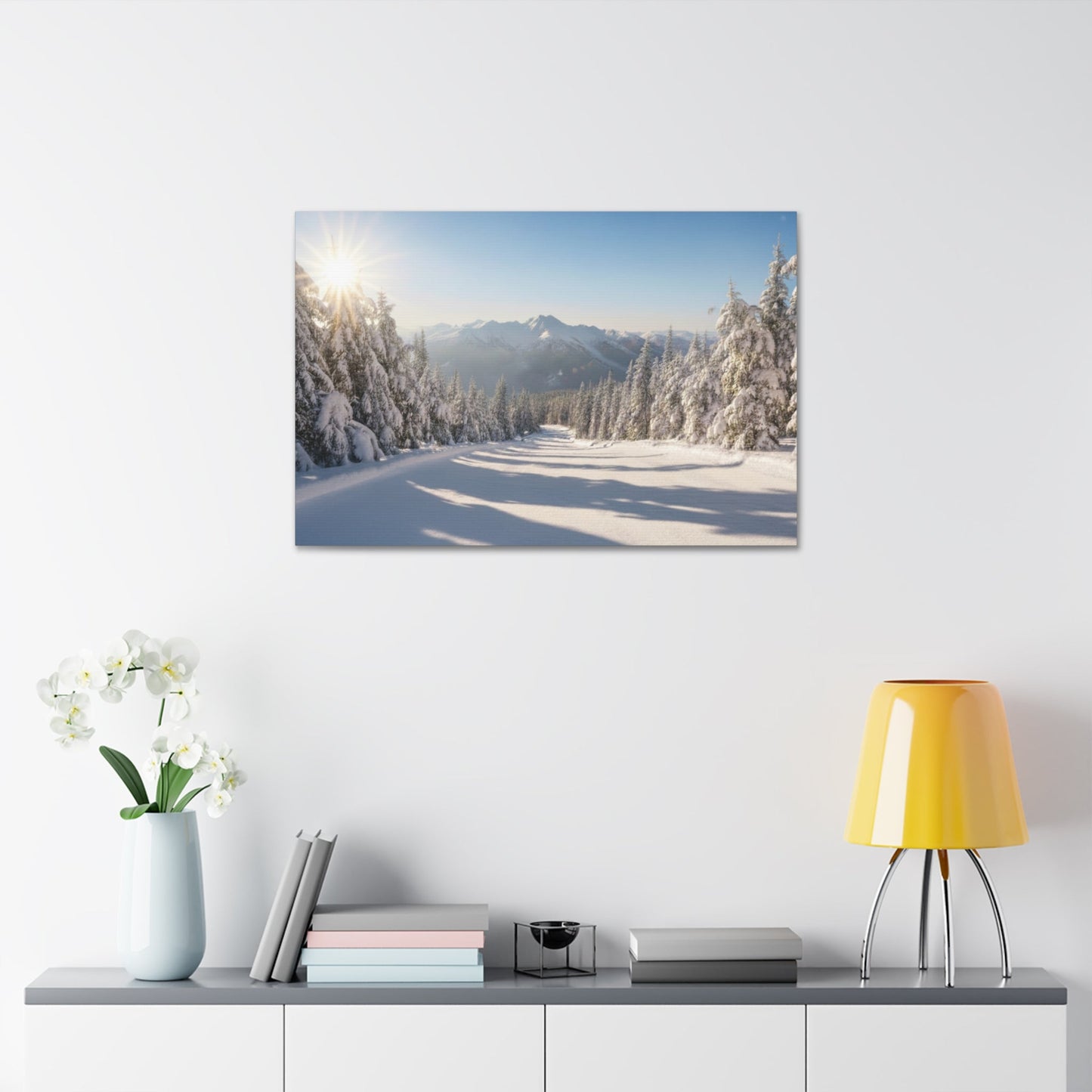 Canvas wall art featuring a serene winter trail with snow-covered trees and mountains under a clear blue sky