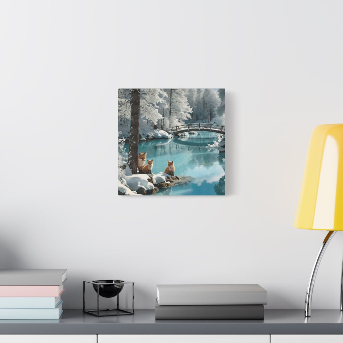 Canvas wall art depicting winter foxes by a serene snowy river with a wooden bridge in the background.