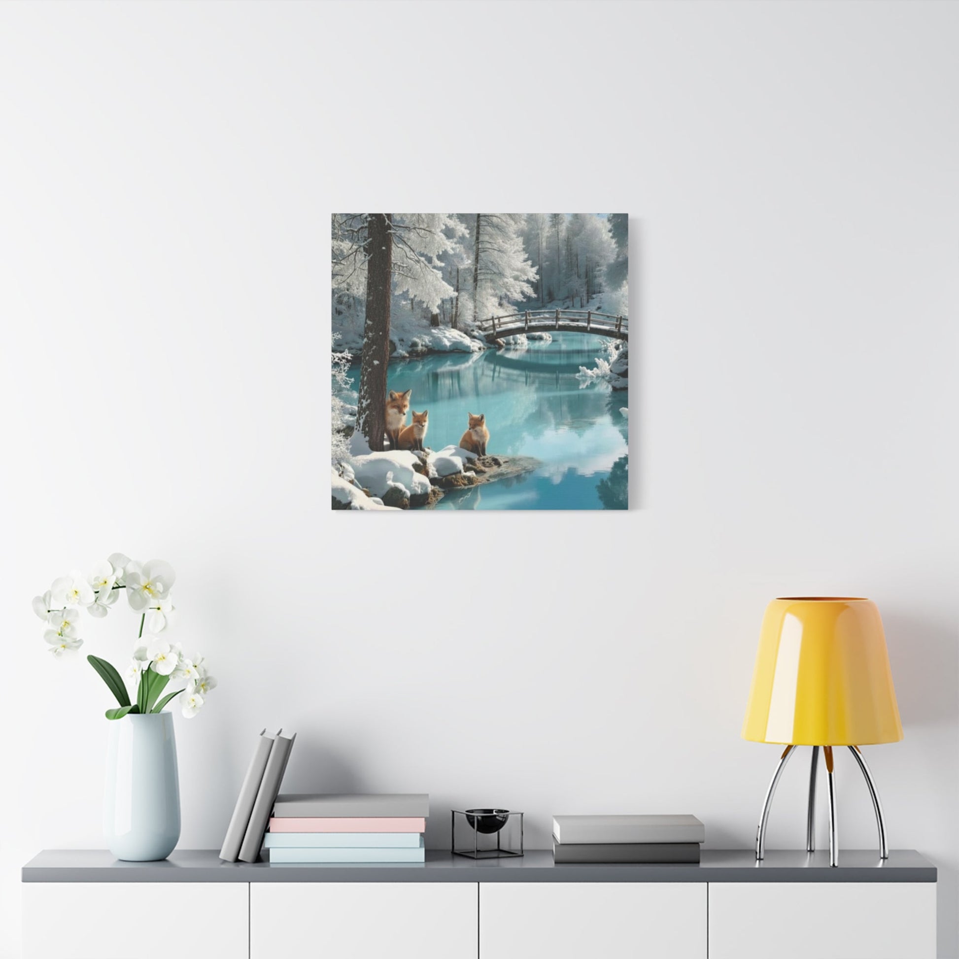Canvas wall art featuring winter foxes by a serene snowy river with a wooden bridge in the background.