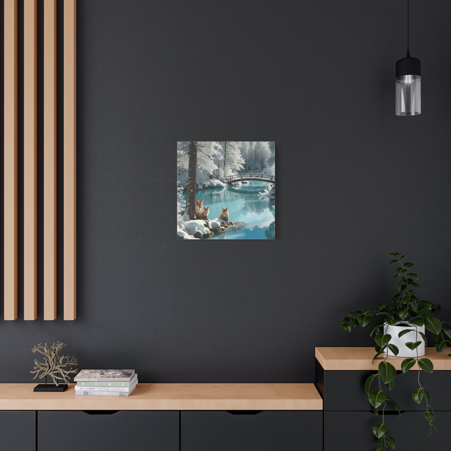 Canvas wall art featuring winter foxes by a serene snowy landscape with a calm river and bridge in a modern room setting