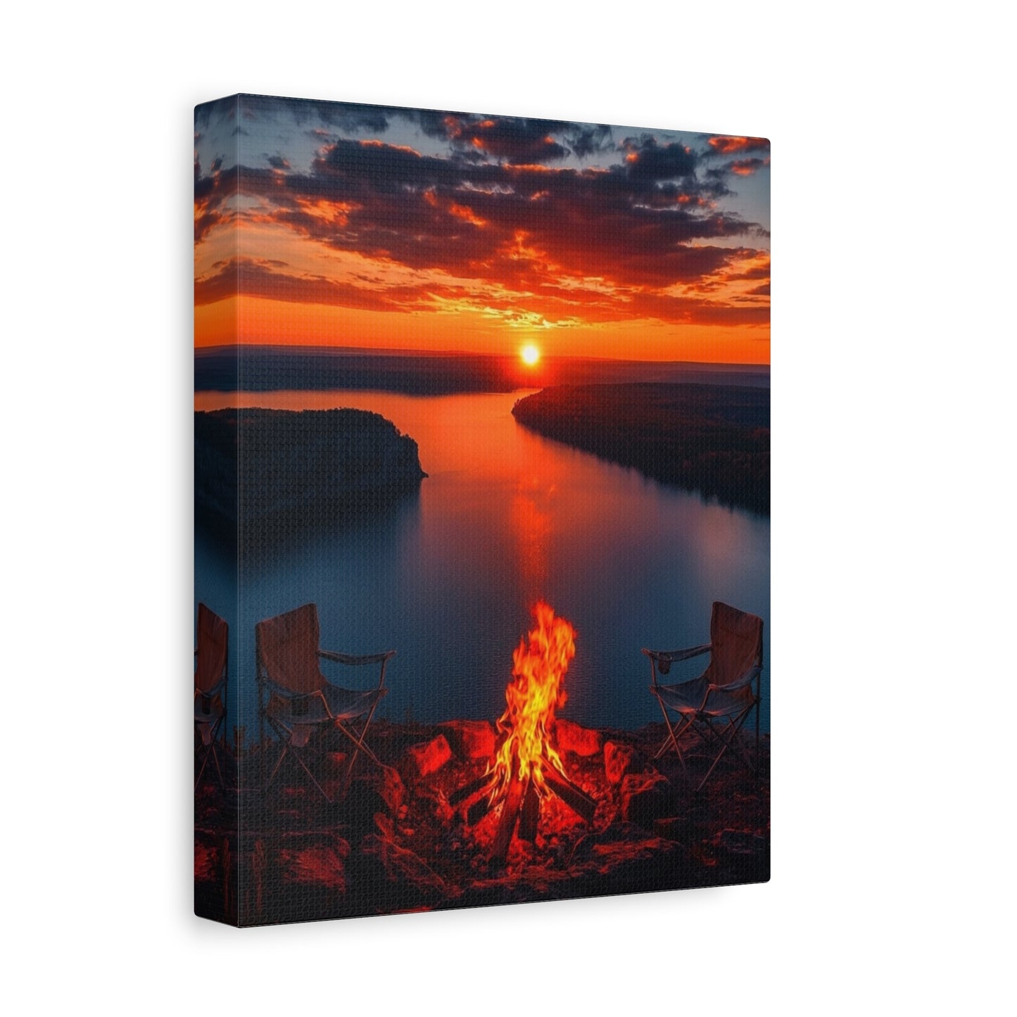 Canvas print of a sunset over a lake with a campfire and chairs.